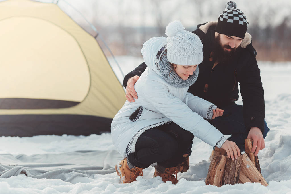 homme et femme mettent du bois de chauffage sur la neige
 - Photo, image