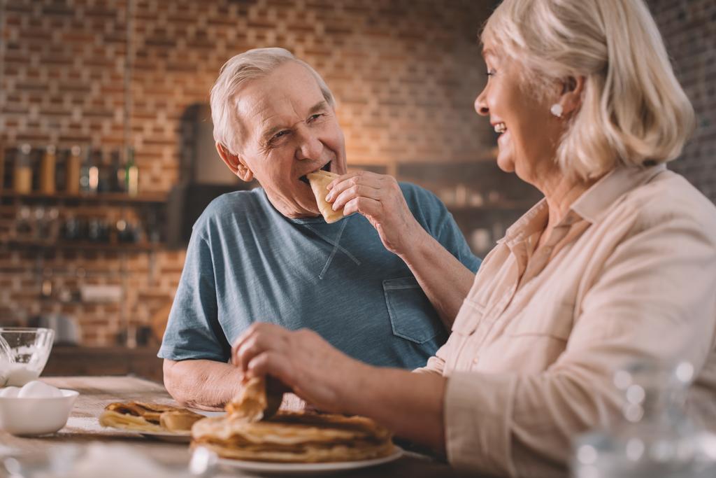 パンケーキを食べている年配のカップル - 写真・画像