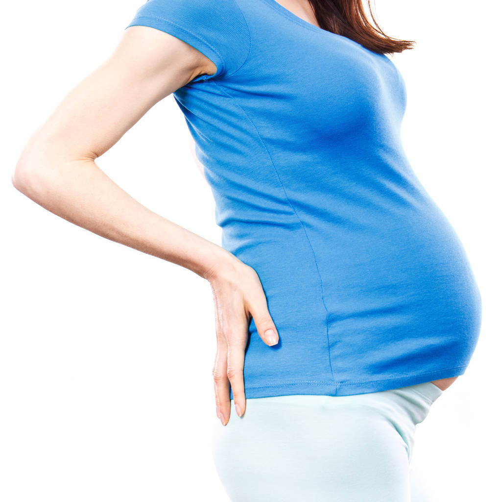 Zwangere vrouw met handen op haar rug, zwangerschap gezondheidszorg en rug pijn - Foto, afbeelding