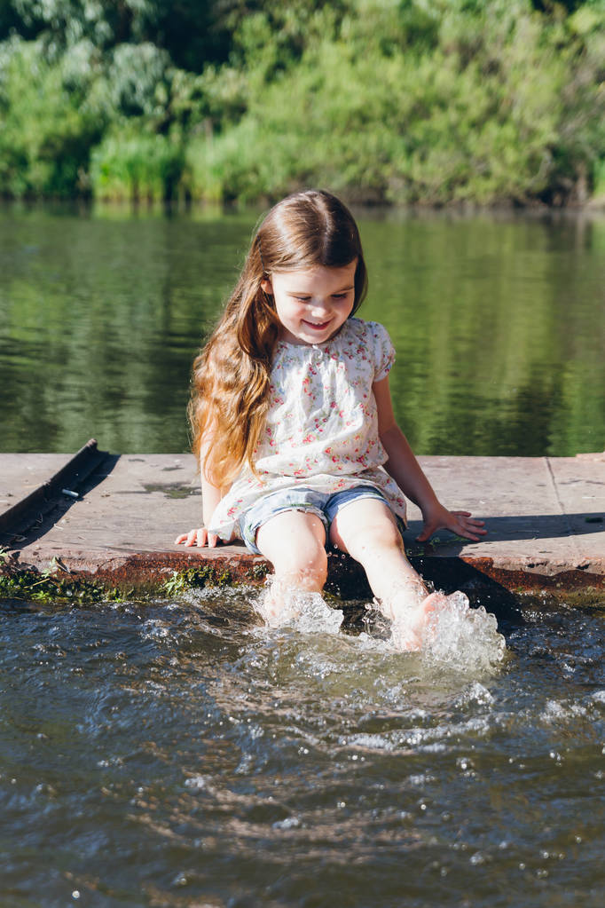 水に足を浸すと笑っている少女 - 写真・画像