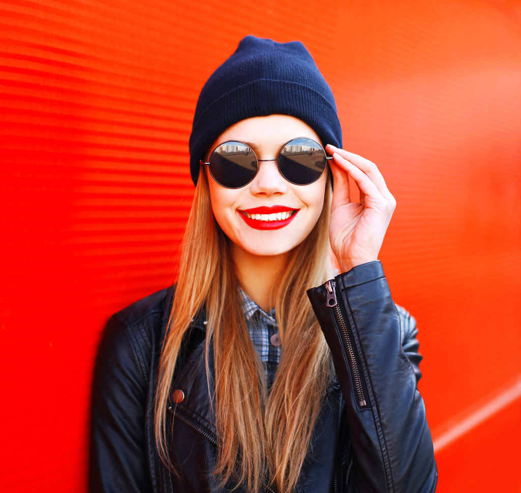 Módní portrét usměvavá blondýnka ve stylu rock černá na červené - Fotografie, Obrázek