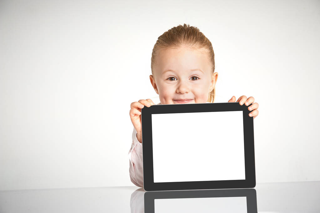 Roztomilé a usmívající se dívka hraje s tabletem - Fotografie, Obrázek