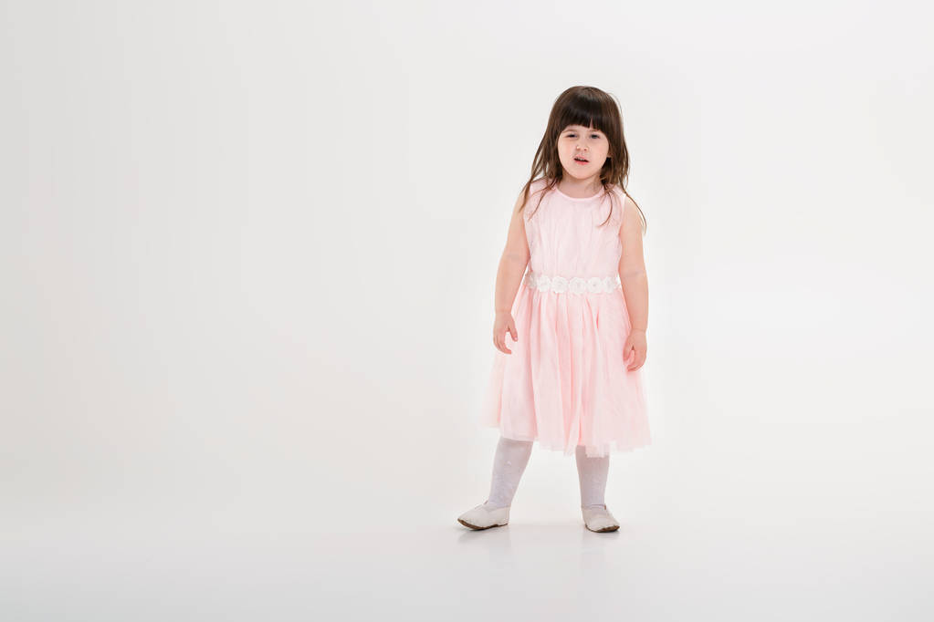 hermosa niña en vestido de princesa rosa en un fondo gris
 - Foto, Imagen