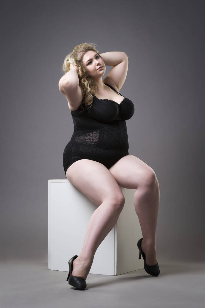 młoda piękna blondynka plus rozmiar model w shapewear xxl kobieta w odchudzające bielizna na szary studio tło - Zdjęcie, obraz