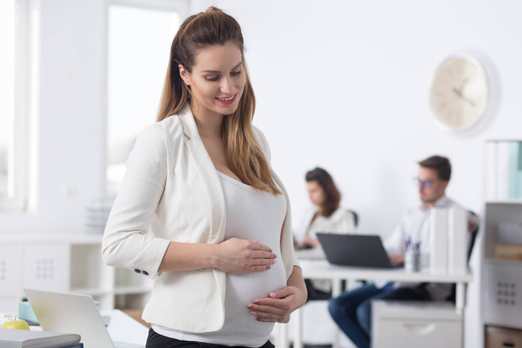 Беременная женщина в светлом офисе
 - Фото, изображение