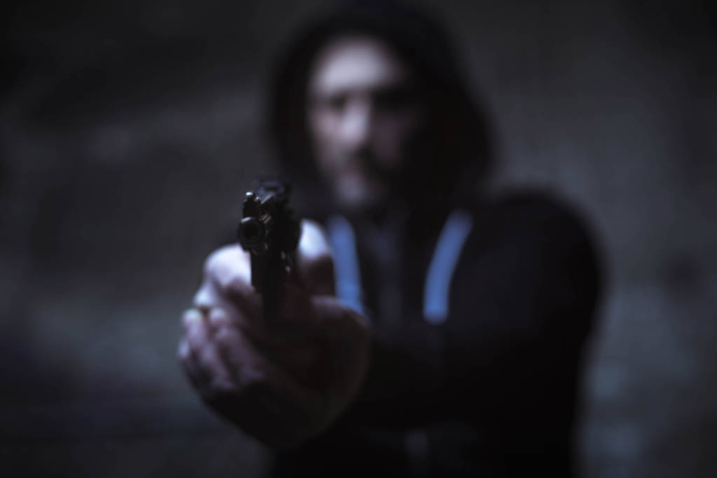 Criminoso perigoso segurando uma arma
 - Foto, Imagem