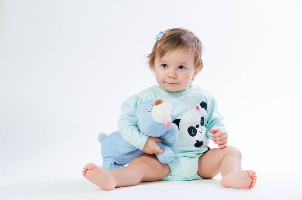 Porträt eines lächelnden Kindes mit einem Spielzeugbär, isoliert auf weißem Hintergrund - Foto, Bild