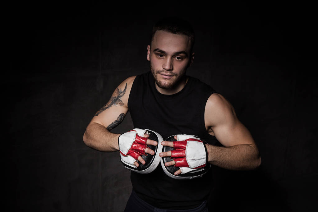 Тренер по боксу с тренировочными перчатками на руках
 - Фото, изображение