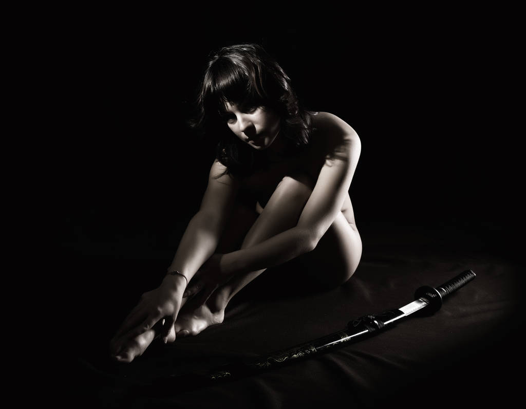 seksikäs alaston nainen miekalla tummalla taustalla
 - Valokuva, kuva