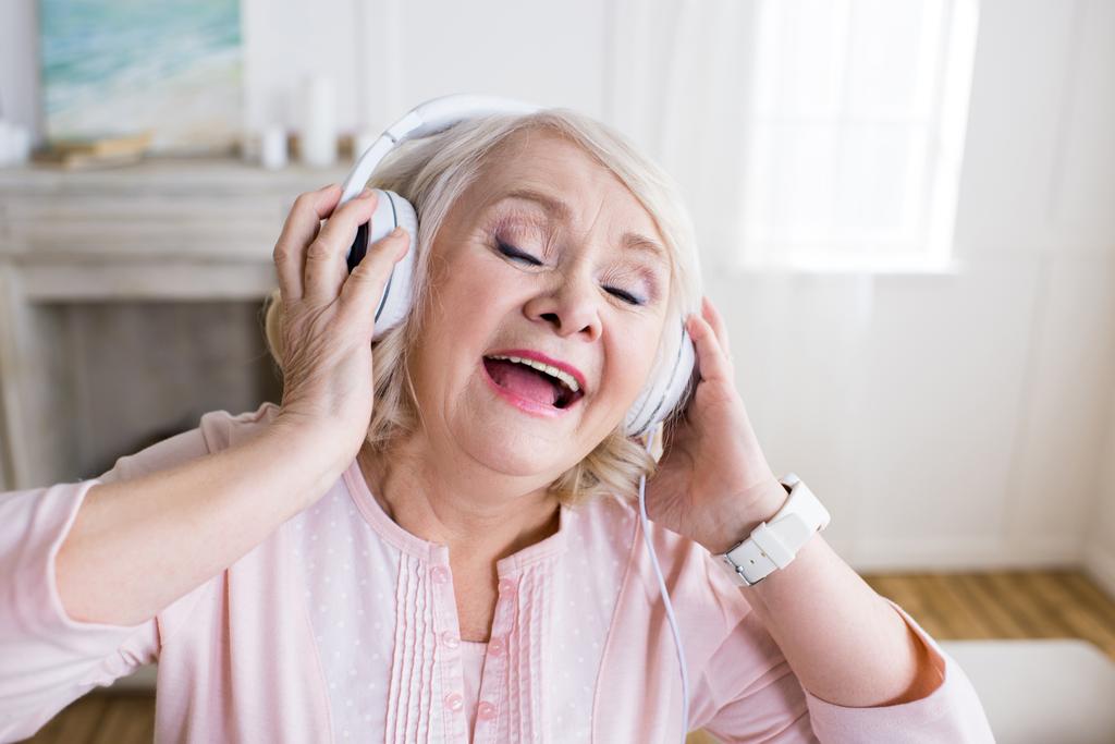 mulher idosa em fones de ouvido
 - Foto, Imagem