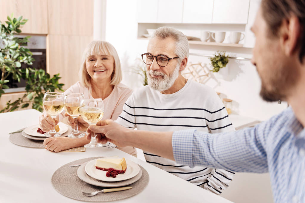 Sorridente coppia anziana gustare la cena con il loro bambino a casa
 - Foto, immagini