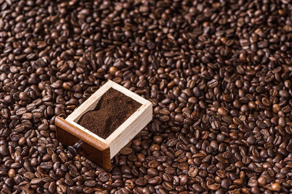 Ground coffee on coffee beans   - Photo, Image