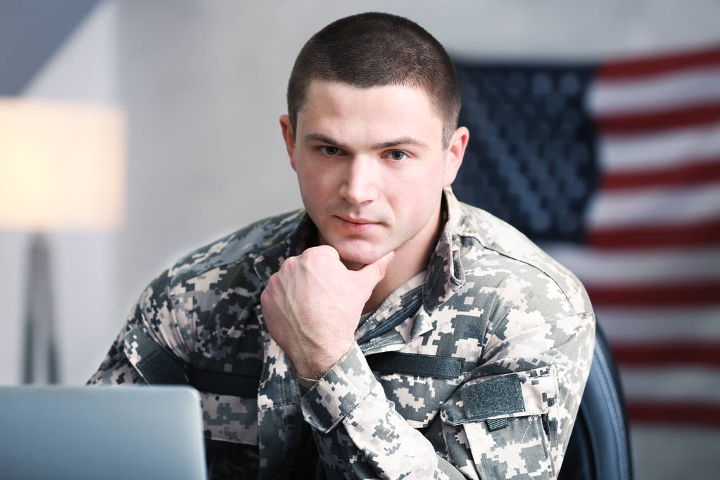 Солдат, який працює з ноутбуком у будівлі штабу
 - Фото, зображення