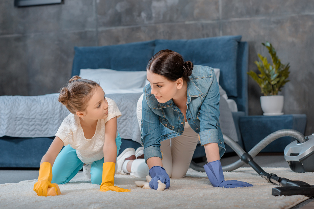Madre e figlia pulizia tappeto
  - Foto, immagini