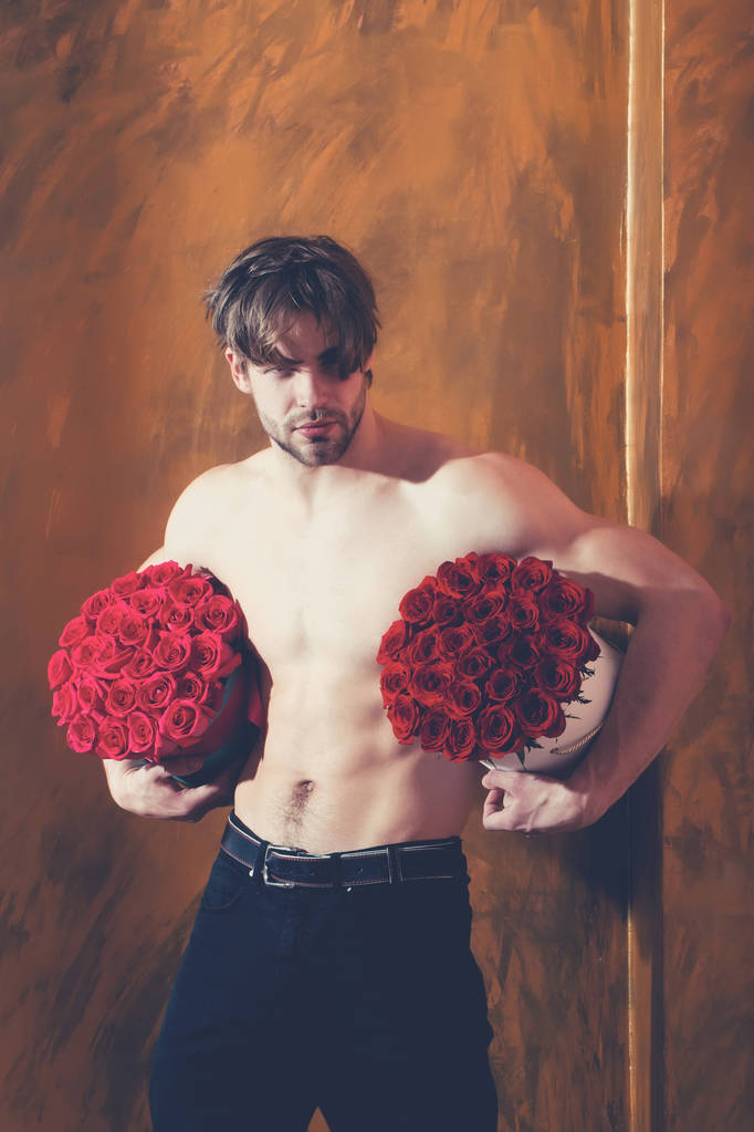 barbudo musculoso hombre con sexy cuerpo sostiene rojo rosa caja
 - Foto, Imagen