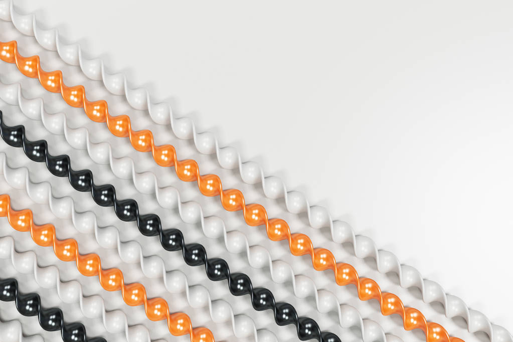Чорні, білі та помаранчеві пластикові спіральні палички на білому фоні
 - Фото, зображення