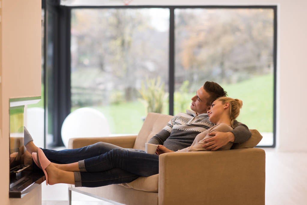 Jovem casal romântico sentado no sofá
 - Foto, Imagem