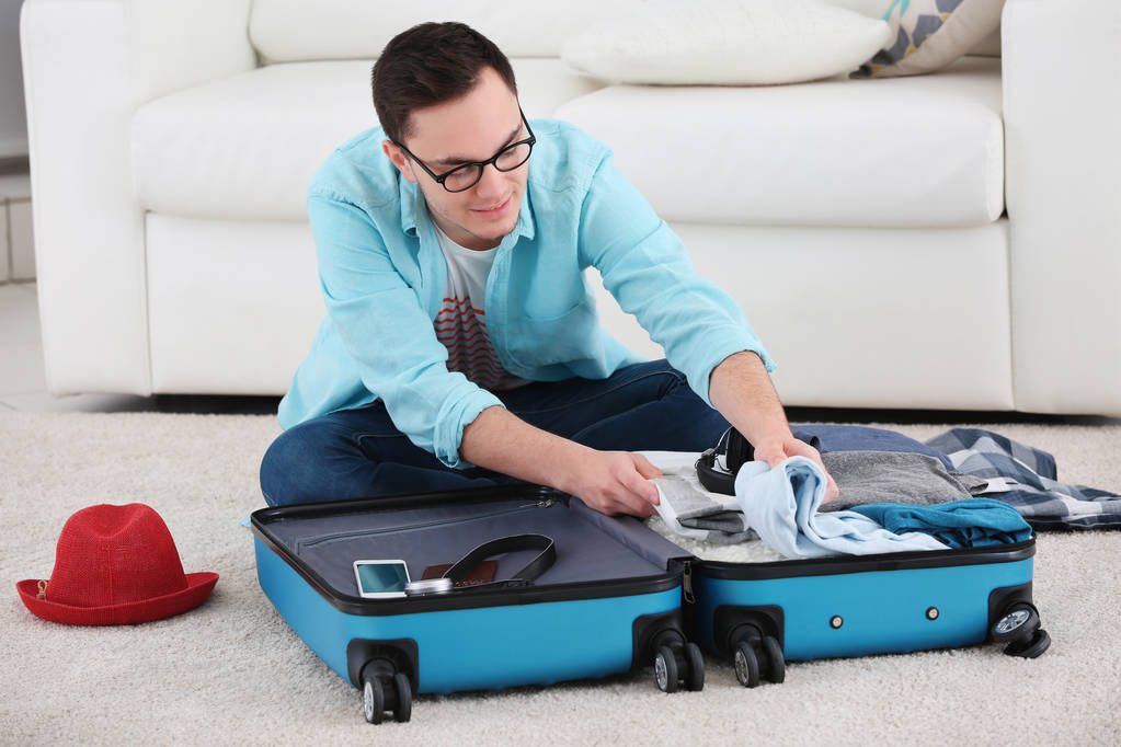Genç adam ambalaj bavul - Fotoğraf, Görsel