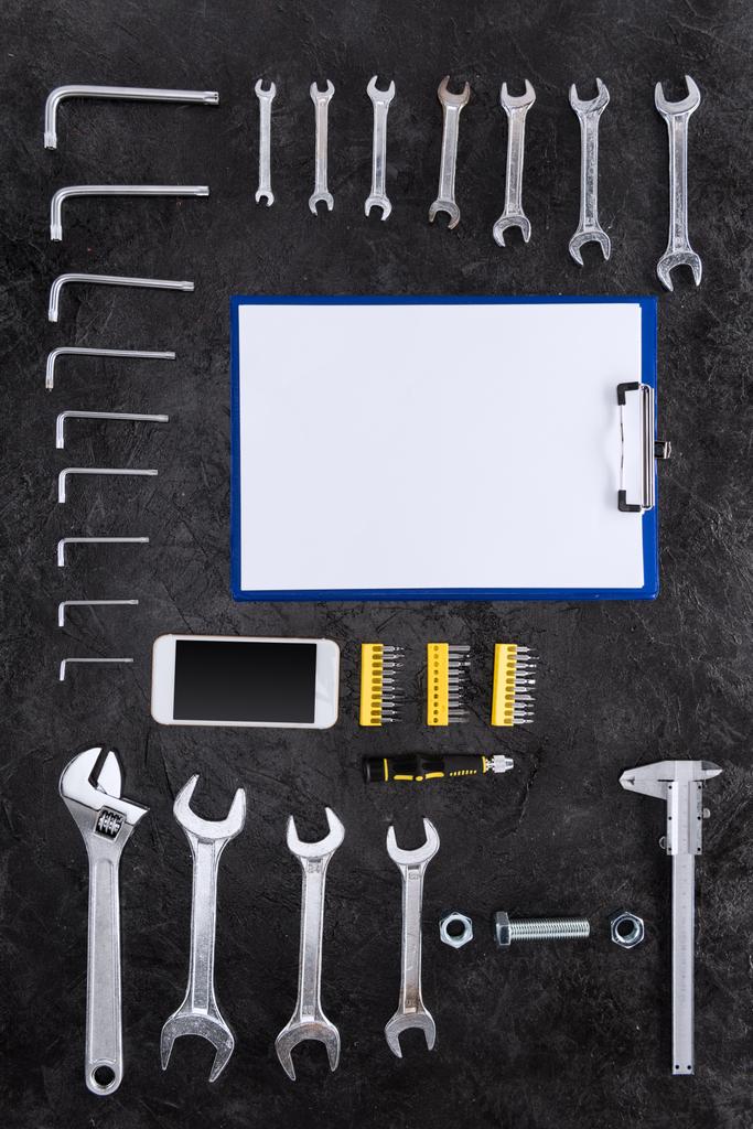 Top näkymä joukko rakennustyökaluja, älypuhelin ja tyhjä leikepöydälle
 - Valokuva, kuva