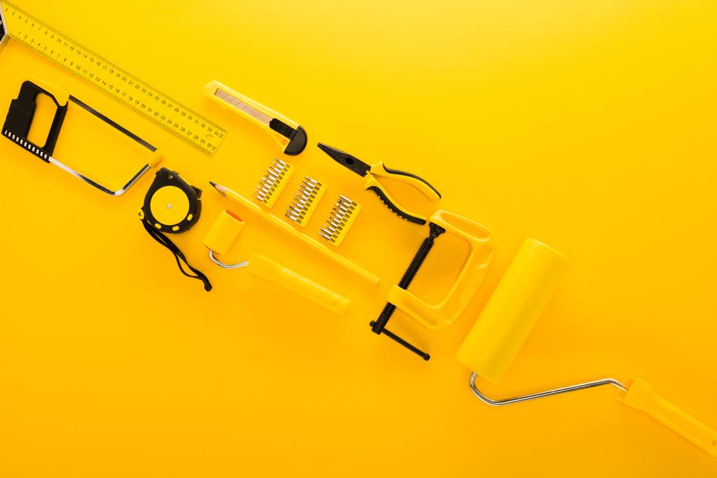 vista superior de varias herramientas de trabajo y regla en amarillo
  - Foto, Imagen
