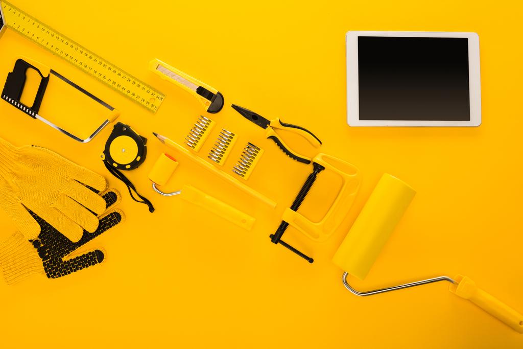 вид зверху на різні робочі інструменти, обладнання та цифровий планшет на жовтому
 - Фото, зображення