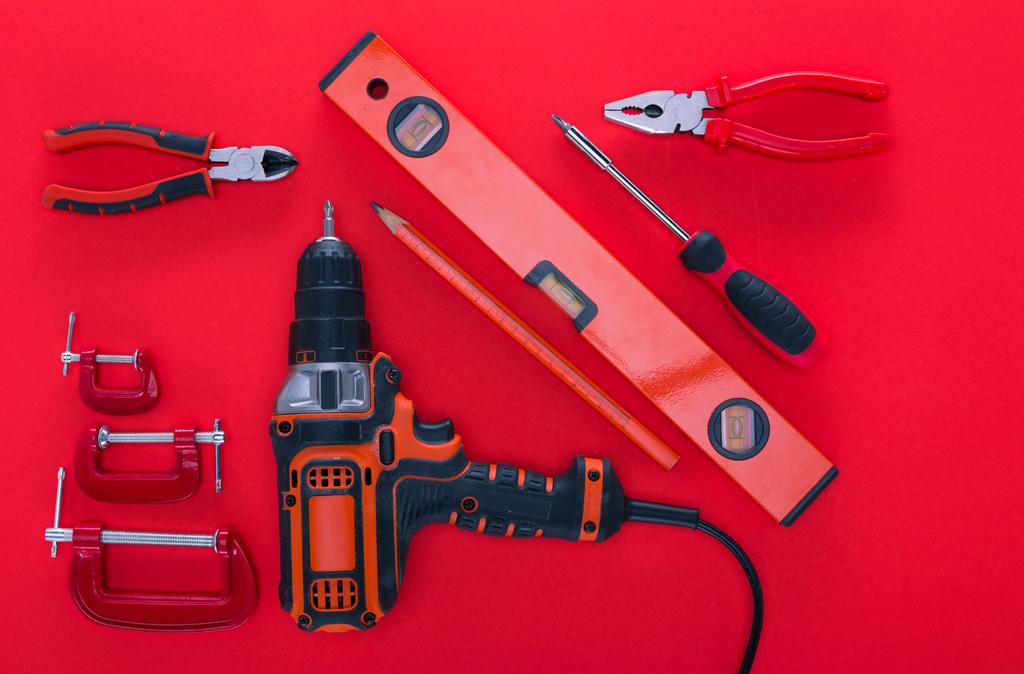 top view of various work tools and pencil on red - Photo, Image