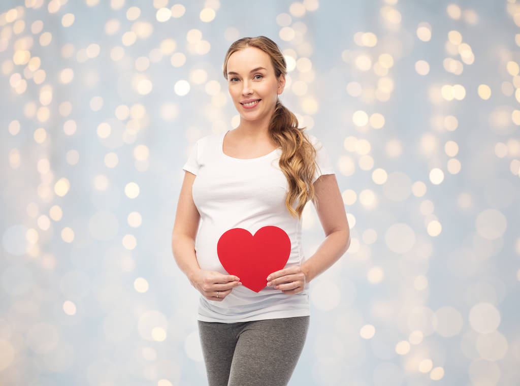 onnellinen raskaana oleva nainen punaisella sydämellä
 - Valokuva, kuva