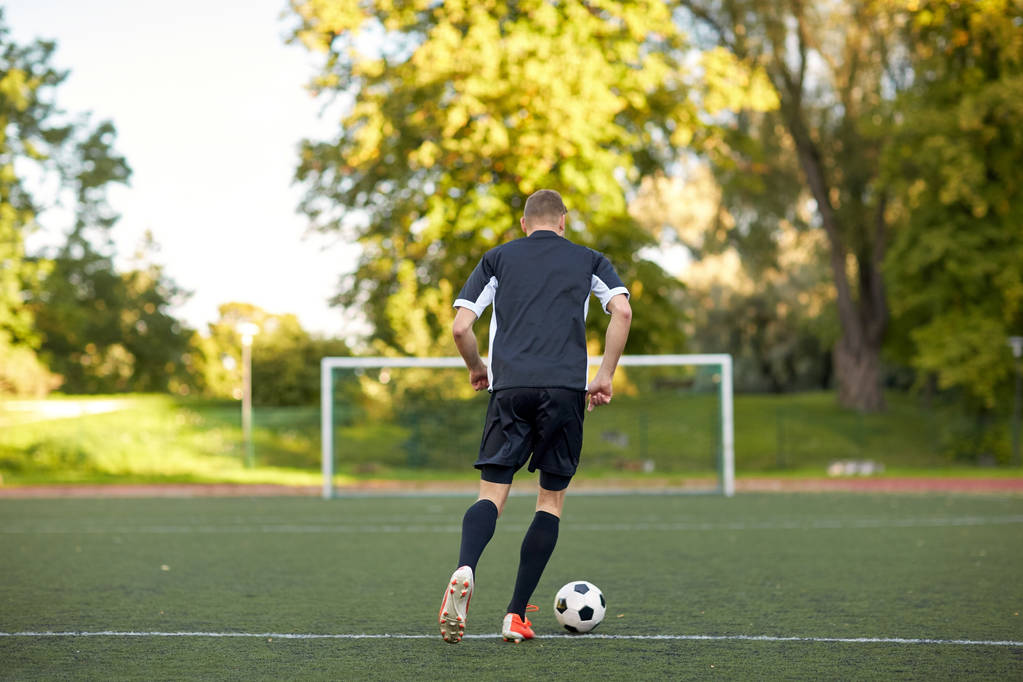 soccer player playing with ball on football field - Photo, Image