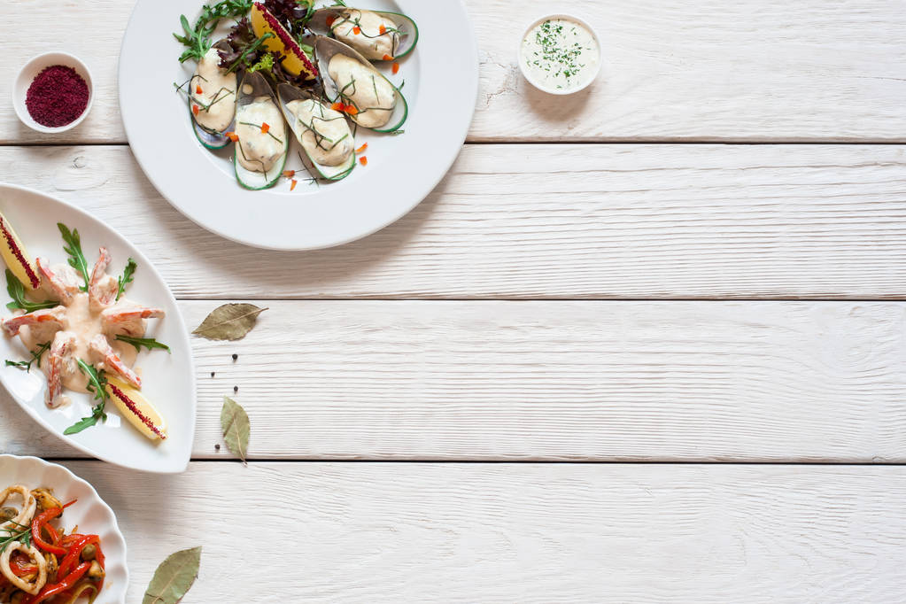 Tavolo in legno bianco con piatti di pesce posa piatta
 - Foto, immagini
