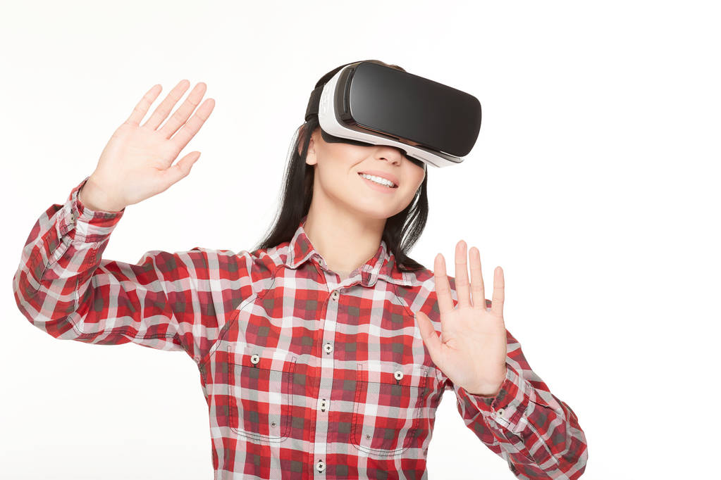 Smiling woman in VR headset touching air by hands. - Photo, Image
