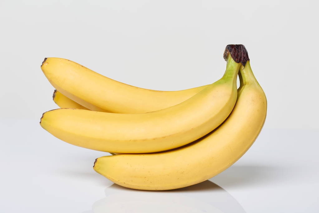 Csomó banán a fehér asztal - Fotó, kép