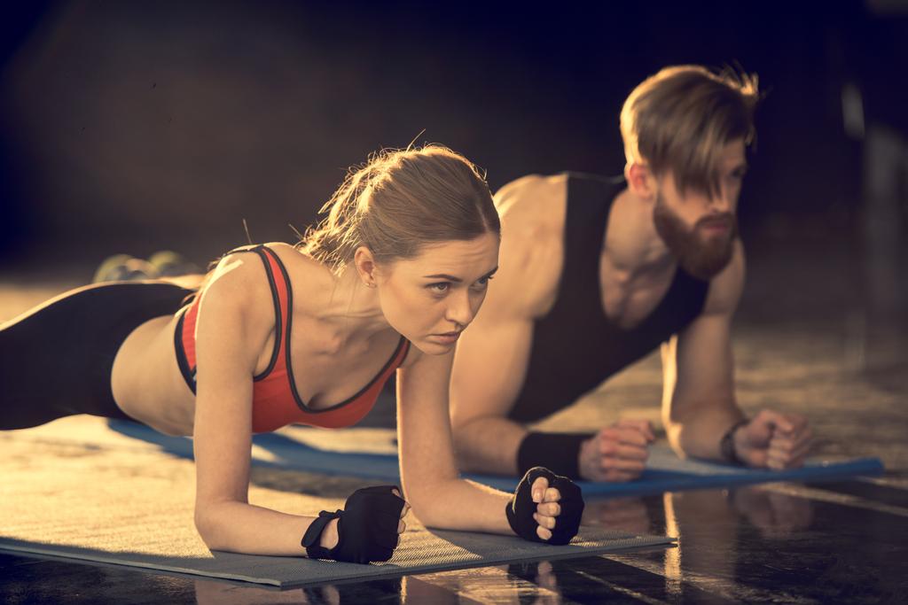 Man en vrouw doen plank oefening  - Foto, afbeelding