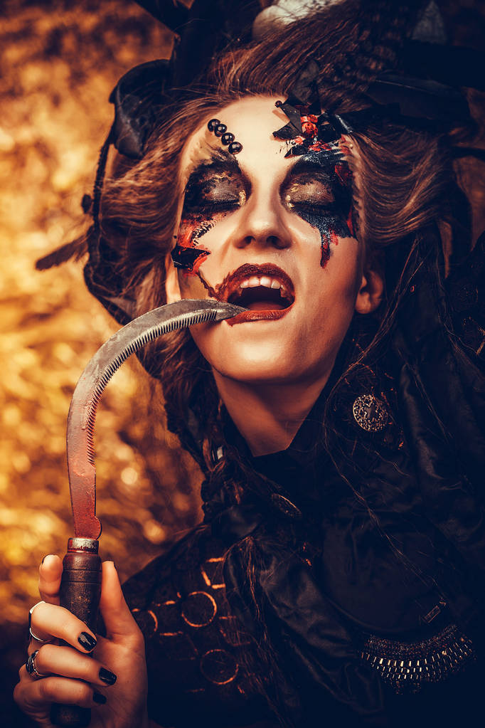 Young  witch hloding sickle. Bright make up, skull, smoke-  halloween theme. - Photo, Image