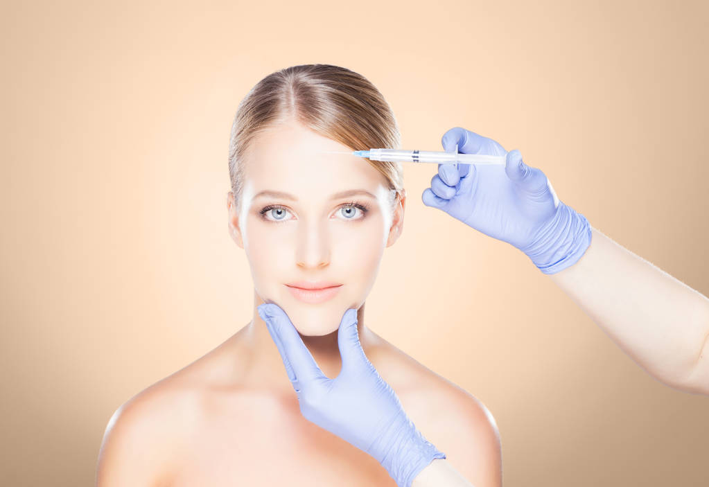 Doctor making injection into face of woman - Photo, Image