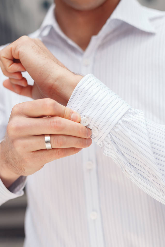 Κοντινό πλάνο ενός επιχειρηματία χέρι πώς φοράει λευκό πουκάμισο - Φωτογραφία, εικόνα