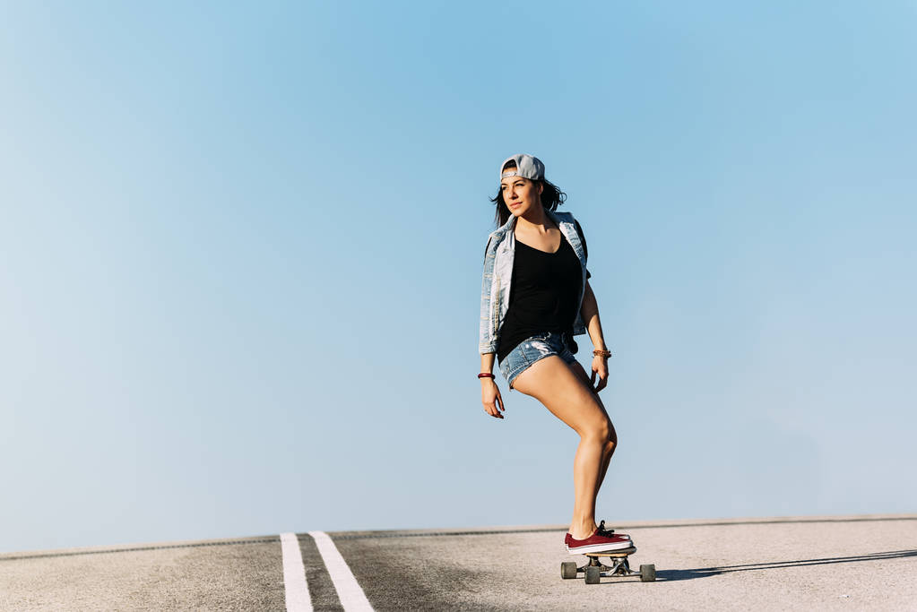 Kobieta piękna skater jazda na jej longboard. - Zdjęcie, obraz
