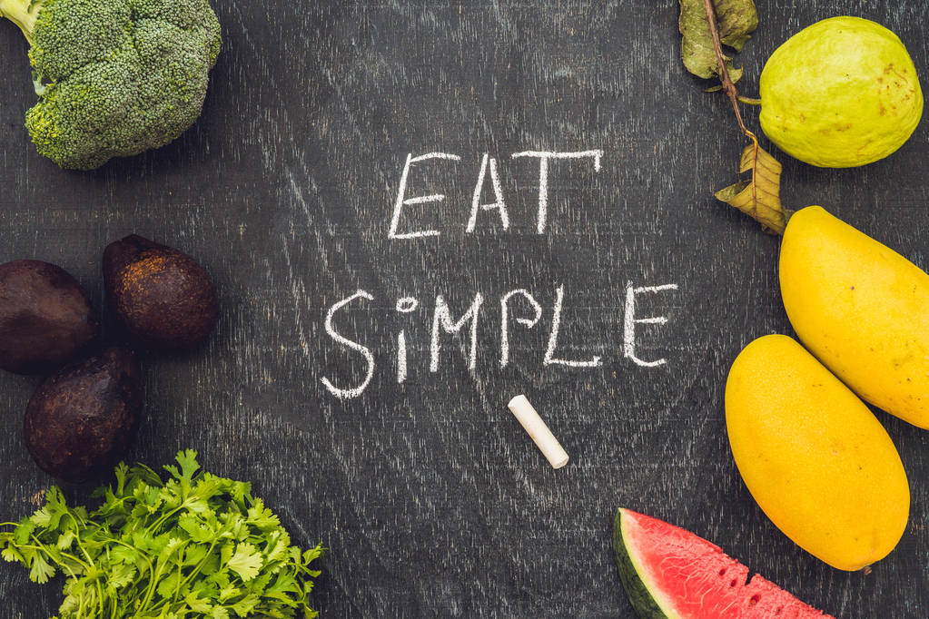 Jíst jednoduché je napsáno na tabuli křídou. koncept čisté jídlo - Fotografie, Obrázek