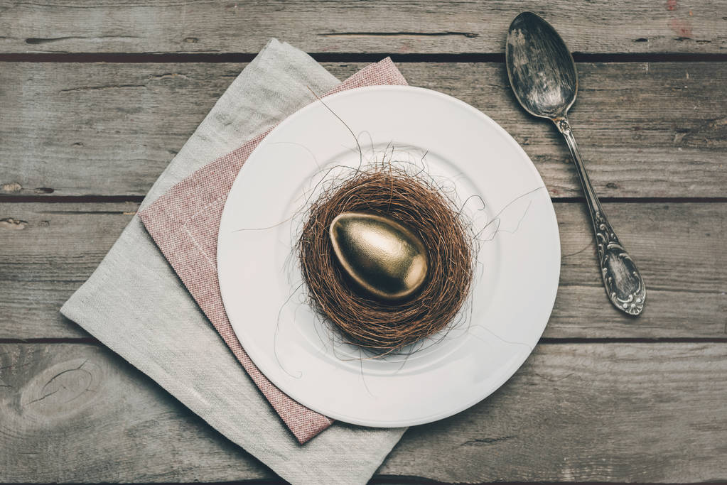 Goldenes Osterei auf Teller  - Foto, Bild