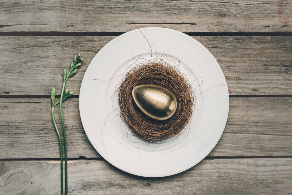Œuf de Pâques doré sur assiette
  - Photo, image