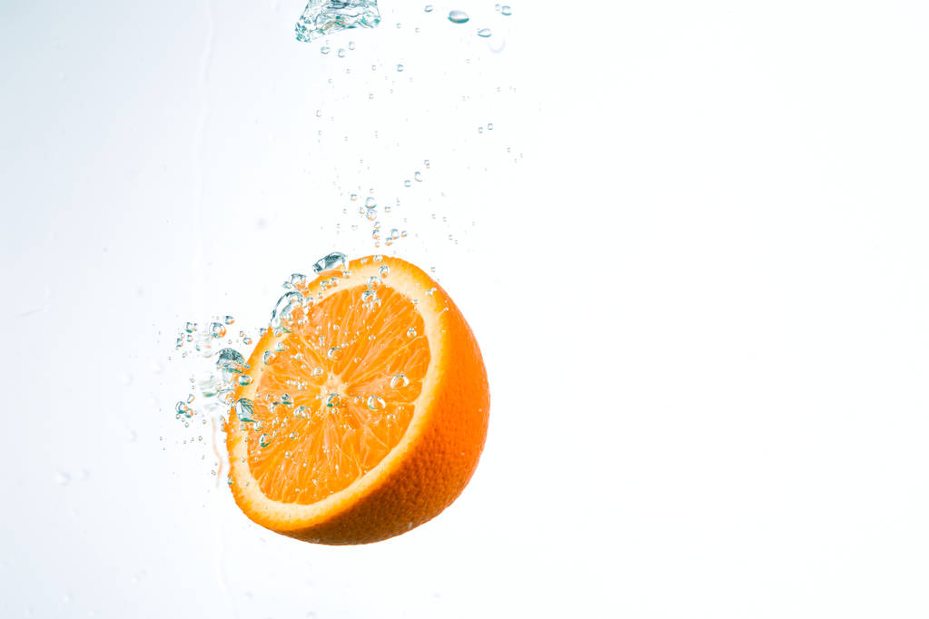 Orange in Wasserströmen auf weißem Hintergrund - Foto, Bild