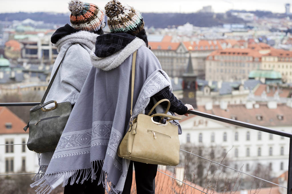 Due giovani donne irriconoscibili guardano la città di Praga dall'alto
. - Foto, immagini