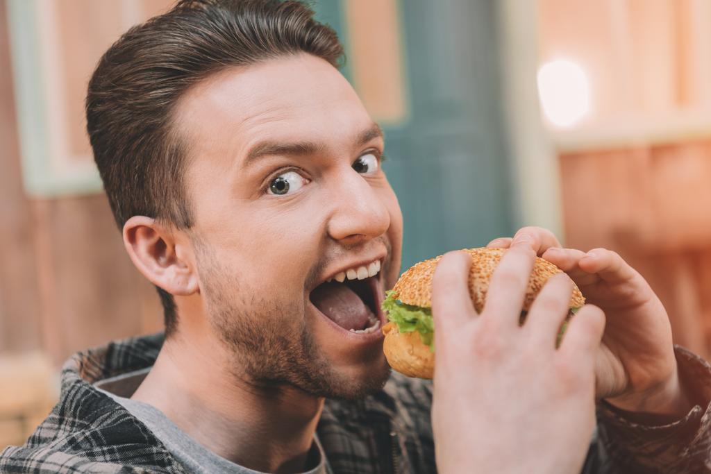 Hombre comiendo hamburguesa
  - Foto, imagen