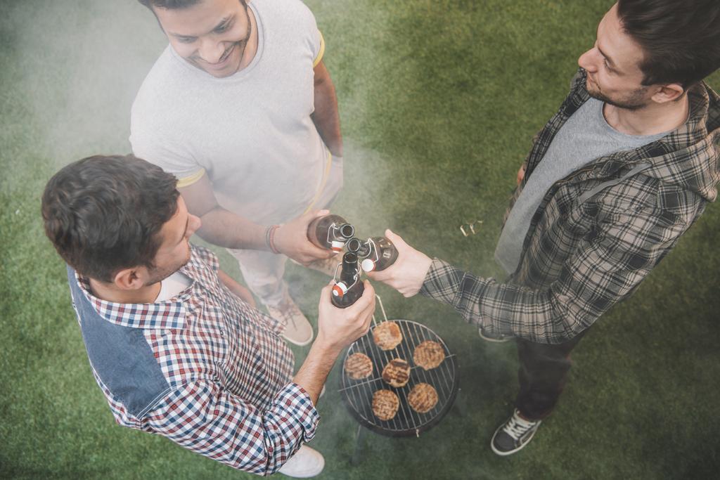 Friends drinking beer and making barbecue  - Photo, Image