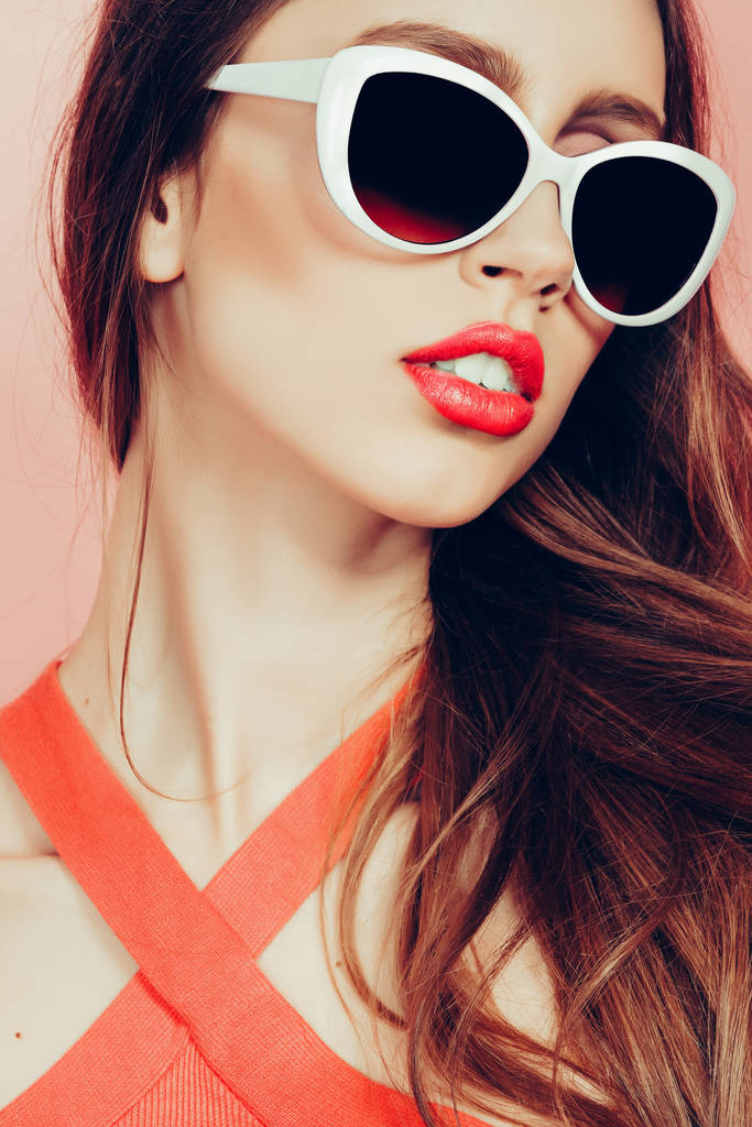retrato de joven hermosa mujer delgada en vestido sexy con labios sensuales en el estudio con gafas de sol sonriendo y posando
 - Foto, imagen