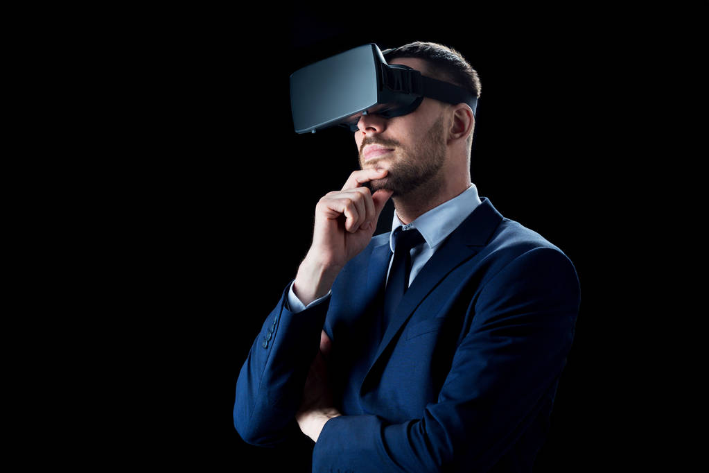 бізнесмен у гарнітурі віртуальної реальності над чорним
 - Фото, зображення