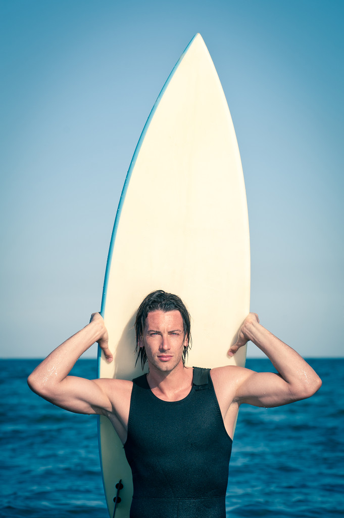Portrait attrayant de jeune surfeur à la plage avec une planche de surf
 - Photo, image