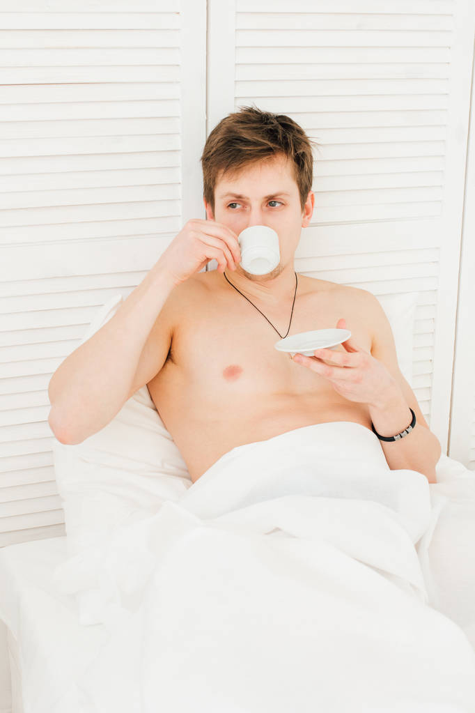 Człowiek pije kawę na śniadanie w łóżku  - Zdjęcie, obraz