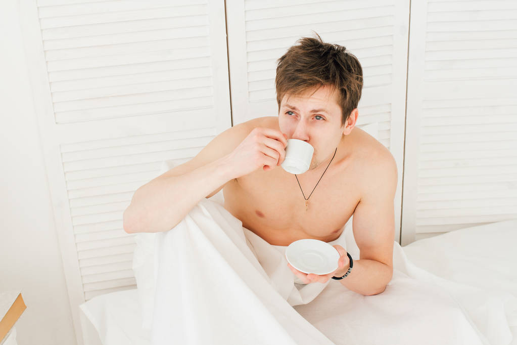 Mann trinkt Kaffee beim Frühstück im Bett  - Foto, Bild