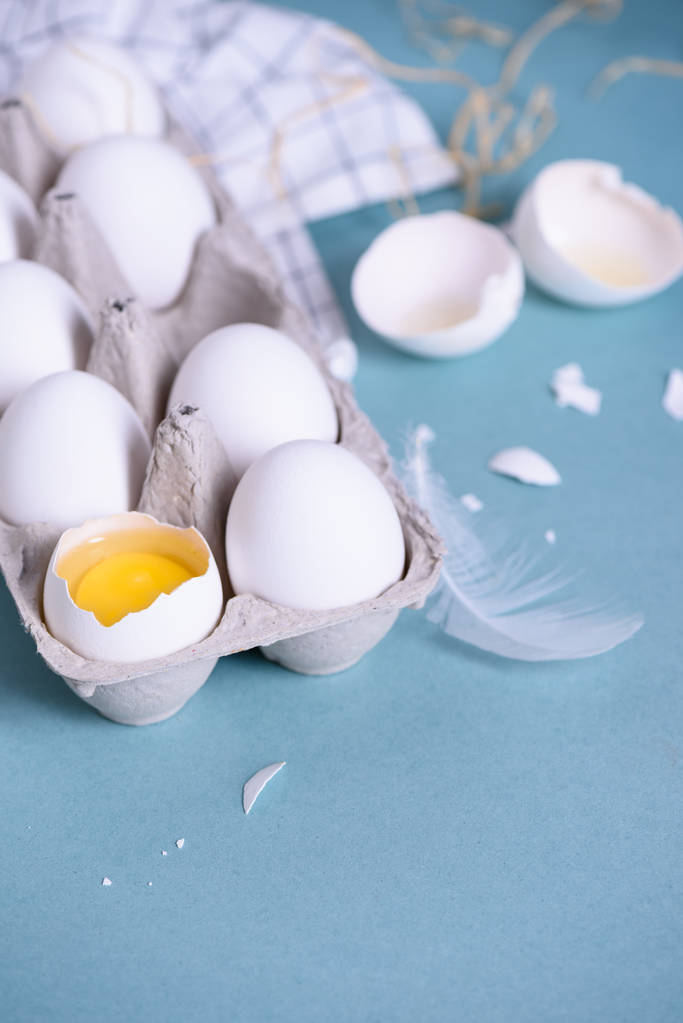 Kananmunia pahvikotelossa sinisellä pohjalla, tuoretta munankeltuaista. Sulje se.
,  - Valokuva, kuva