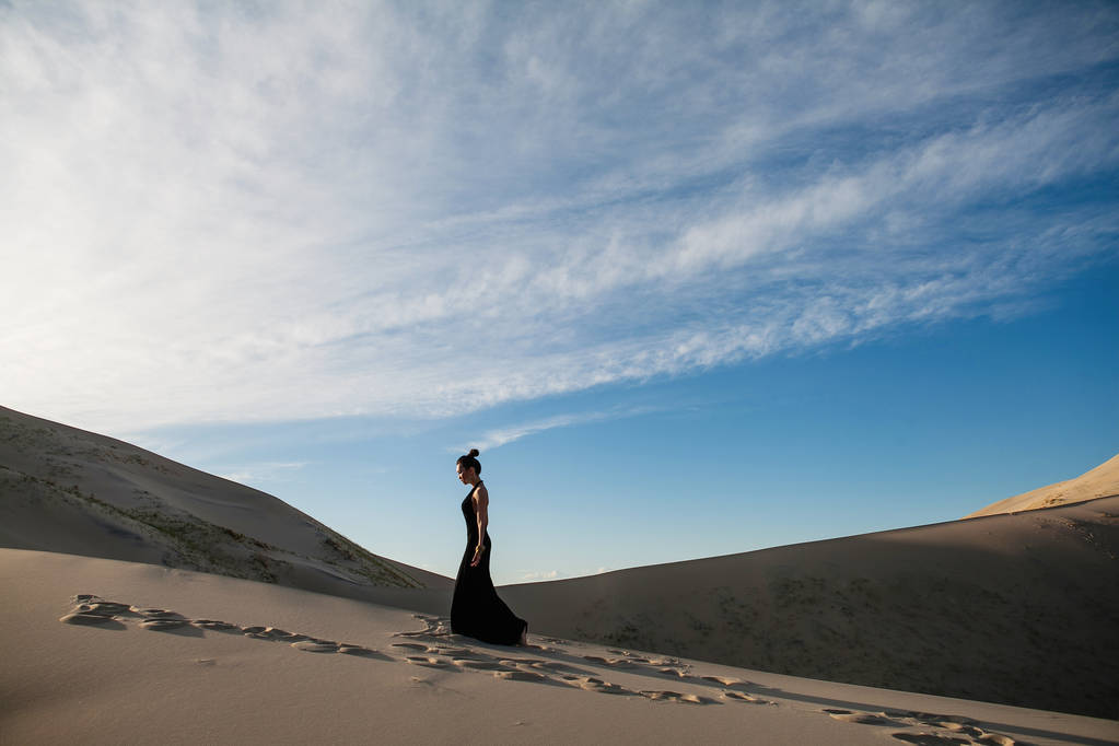 schöne Frau in einem langen schwarzen Kleid Wüstenlandschaft - Foto, Bild